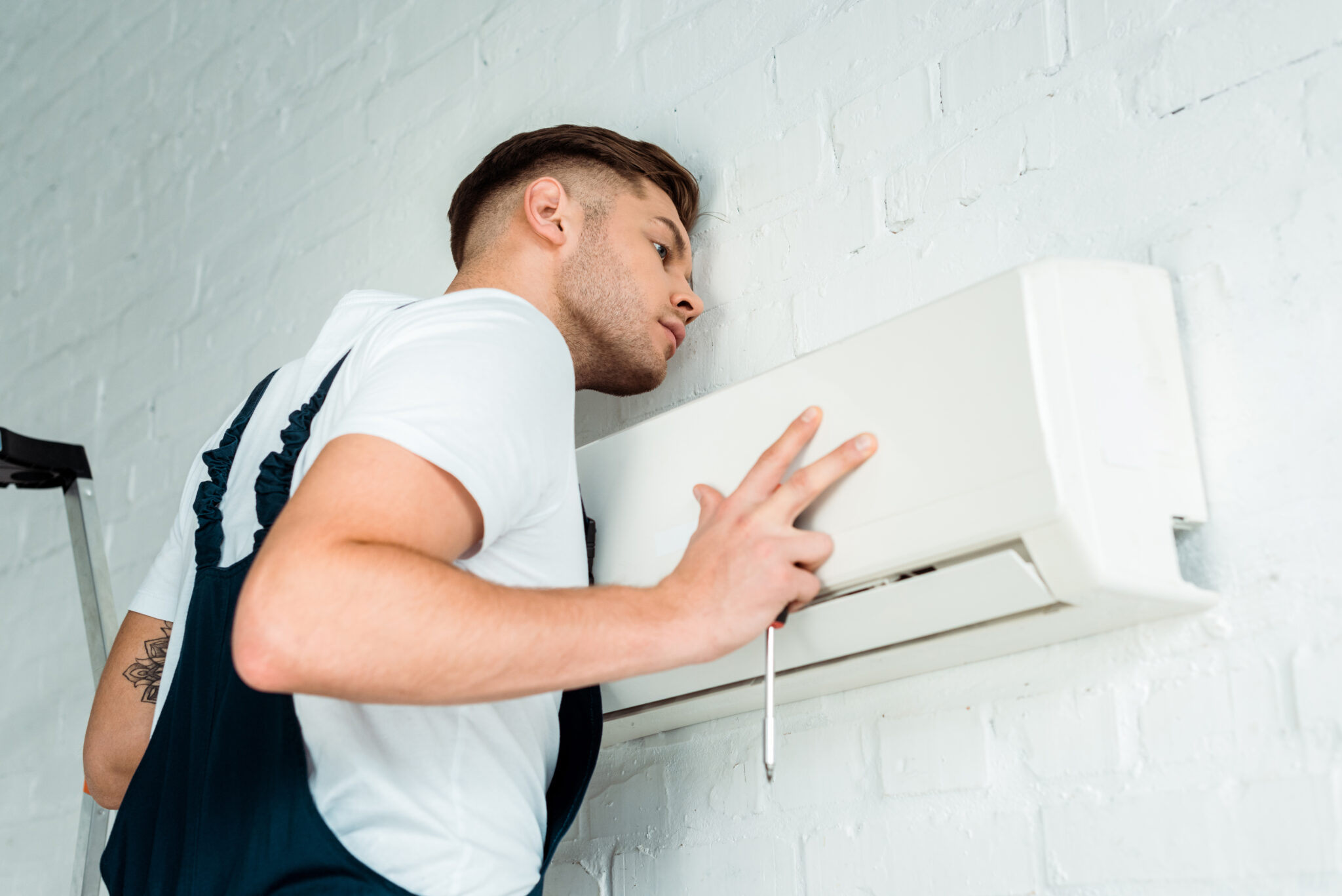 handsome worker installing air conditioner